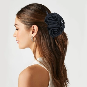 Elegant large black satin rose flower hair claw clip worn by a model in a side view