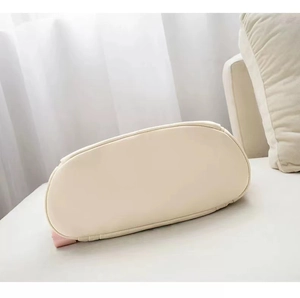 Detail view of the oval-shaped bottom base and neat stitching of this beige oxford backpack