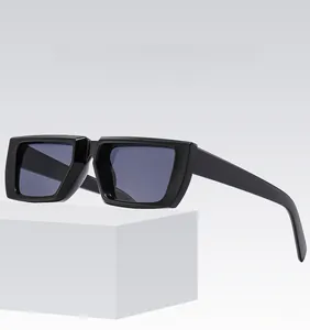 Detailansicht der schwarzen Oversized-Sonnenbrille mit grauen Gläsern auf weißen Blöcken