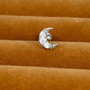 Macro shot of a silver moon-shaped stud earring with cubic zirconia on a velvet tray