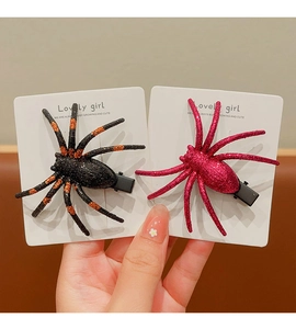 Detail of two glitter spider hair clips in black and pink for Halloween parties