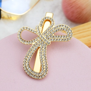 Close-up of golden butterfly hair clip with sparkling rhinestones and pearl detail