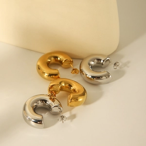 Detail shot of chunky hollow C-shaped hoop earrings in gold and silver stainless steel
