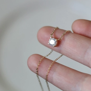 Close-up of a sparkling 1-carat zircon pendant on a fine 14K gold plated silver necklace