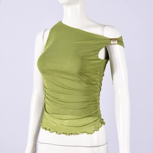 Détail d'un haut asymétrique en mesh vert avec fronces et boucle métallique dorée