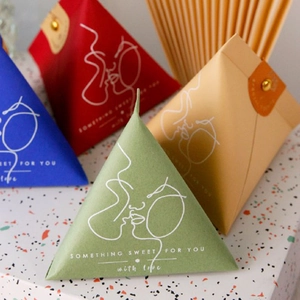 Detail of pyramid paper gift boxes with leather snaps in various elegant colors