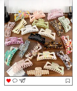 Flat lay of oversized acetate hair claws with tortoiseshell and marble patterns on wood