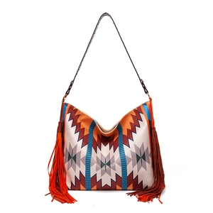 Detail of bohemian woven shoulder bag with ethnic patterns and long side tassels