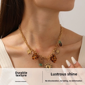 Detailed view of vintage gold-plated necklace with acrylic heart and sun charms