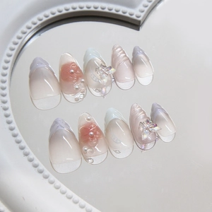 Pink blush press-on nails with 3D butterfly, pearls and French tip on a mirror surface