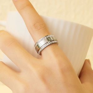 Detail of silver band ring featuring Roman numerals and sparkling side stones
