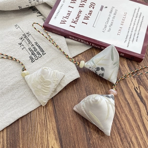 Detailed view of handmade silk zongzi charms with colorful cords and jade beads