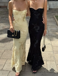 Detailed close-up showing 3D floral embroidery on tight beige and black maxi dresses