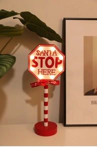 Detail of Santa Stop Here LED road sign with red bow and warm glowing lights