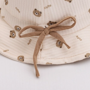 Cute cotton baby bucket hat with bear print and soft ribbon bow in cream rib knit