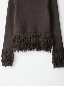 Détail de la veste en maille marron foncé avec ourlet à franges et ornements de manches