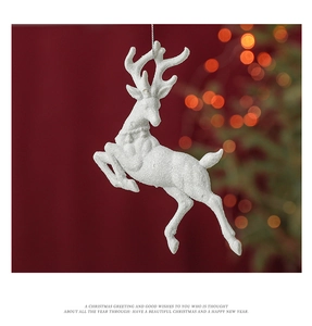 Sparkling white reindeer ornament with glitter finish hanging on a festive Christmas tree