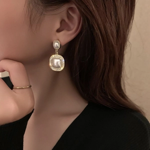 Detailaufnahme der Vintage-Strass- und Perlenohrringe am Model in eleganter Goldoptik