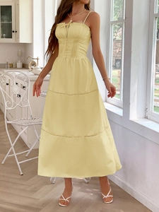 Detail view of light yellow midi dress with pleated bodice and hollow-out lace layers