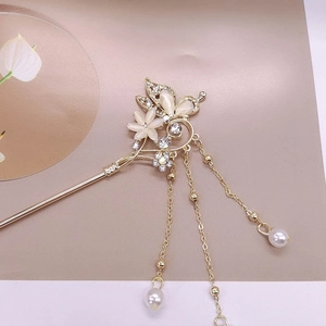 Détails de l'épingle à cheveux dorée avec papillon œil de chat et glands de perles
