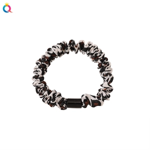 Leopard print ruched scrunchie with chic monochrome pattern and cylindrical accent