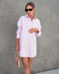 Détail d'une robe chemise rose clair surdimensionnée à manches longues en tissu tissé
