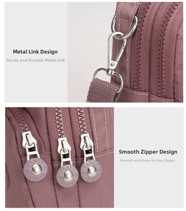 Detail of durable nylon shoulder bag featuring triple zippers and star-shaped metal pulls