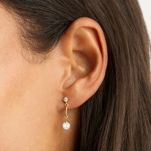 Close-up of elegant S925 silver pearl drop earrings with diamond studs on a female model