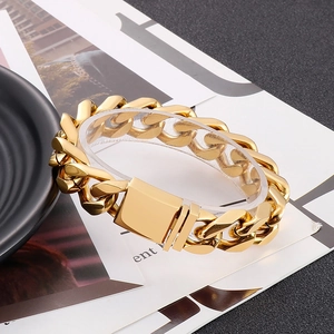 Gros plan sur un bracelet gourmette doré avec fermoir carré sur fond décoratif