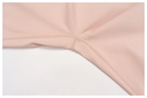 Detail of professional flatlock stitching on pink high-stretch sports leggings