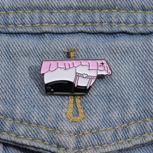Vue macro d'un pin's en émail représentant une jupe rose à volants et un porte-jarretelles
