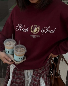 Gros plan d'un sweat bordeaux à col rond avec broderie couronne et graphisme lettré