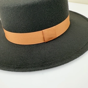 Close-up of wool fedora hat with orange grosgrain ribbon detail and felt texture