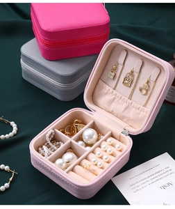 Detail view of portable jewelry boxes in pink and grey showing interior hooks and slots