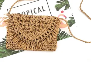 Close-up of handmade paper rope woven bag with long decorative fringe and straw texture