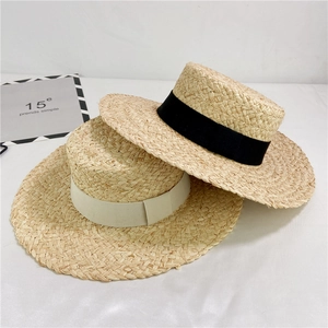 Handwoven raffia sun hat with wide brim and elegant grosgrain ribbon for beach vacation