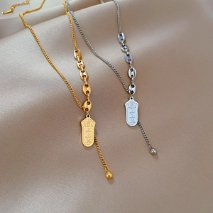 Minimalist pig nose link necklace with rectangular engraved pendant on silk background