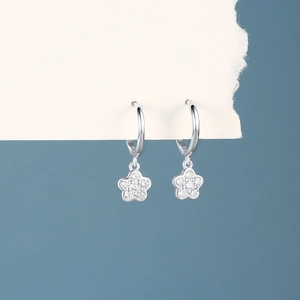 Macro detail of silver star hoop earrings featuring sparkling pave white zircon stones