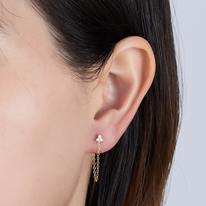 Detailed macro view of a golden S925 silver flower stud earring with a hanging chain tassel