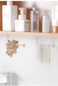 Close-up of wall-mounted L-shaped glitter hook for jewelry and headband storage