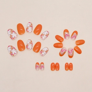 Short round orange false nails with white five-petal flower and dot designs
