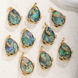 Détail de huit pendentifs en nacre plaqués or en forme de goutte avec motifs de feuilles