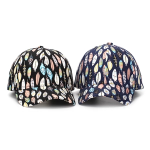 Detailed view of feather print baseball caps in black and navy with vibrant colorful patterns