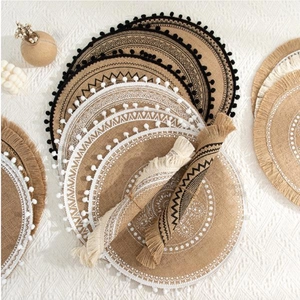 Detail of round jute placemats set with tassels and geometric patterns in natural tones