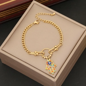 Detailed shot of gold Hamsa Hand bracelet with colorful rhinestones and Cuban link chain