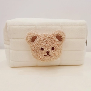 Close-up of soft white quilted plush stationery bag featuring a brown bear embroidery