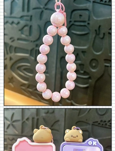 Close-up view of pink pearly bead strap and cute bear sliding puzzle keychain details