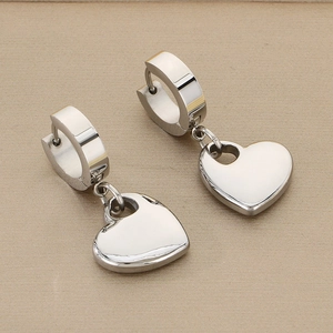 Macro detail of silver hollow heart pendant earrings with mirror polished finish