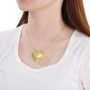 Gros plan d'un collier avec pendentif cœur doré poli sur un modèle pour la fête des mères