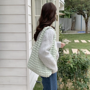 Detail of mint green popcorn texture tote bag showing its soft fabric and slouchy fit